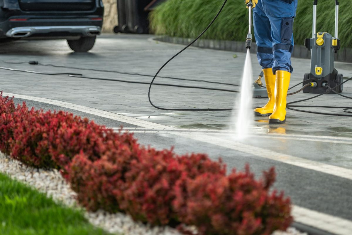 Pressure washing a paved driveway